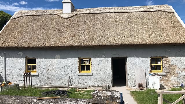 The farmhouse during restoration, stone walls exposed, scaffolding up